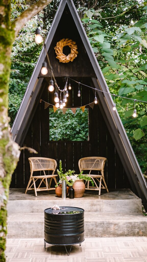 brown wooden chairs and table near green trees during daytime